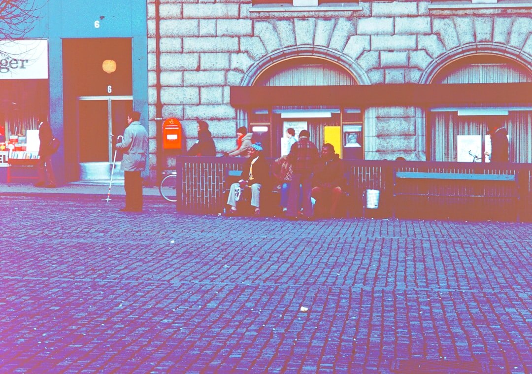 Documentary photographer taking pictures of people talking on a street in a Danish town